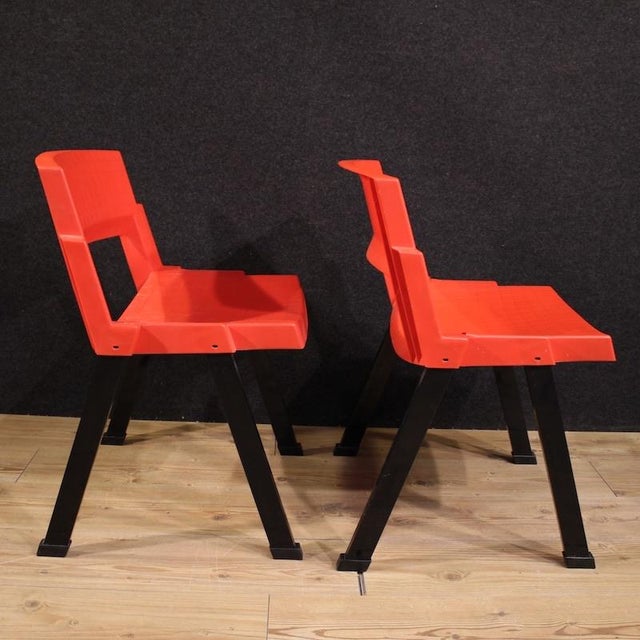 Pair of Italian chairs from the 1980s. The seats and backrests are made of red polypropylene, with black painted metal...