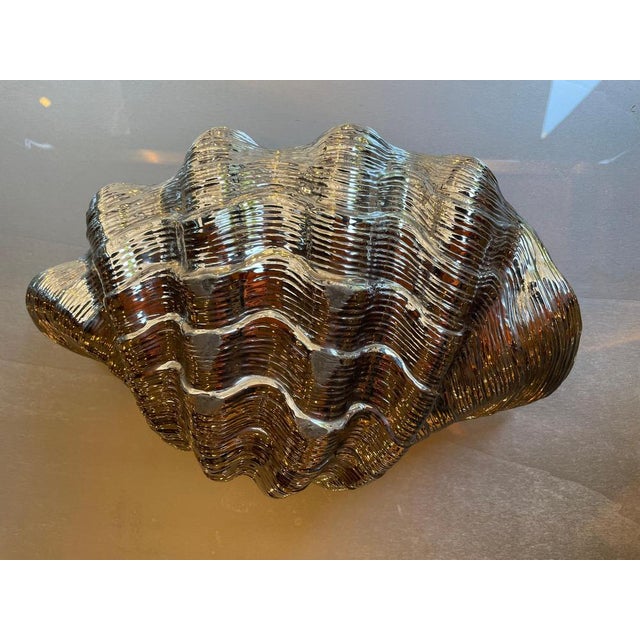 Elegant shell-shaped catchall in ceramic with gold and silver finish. Often used as a stylish decorative piece or...