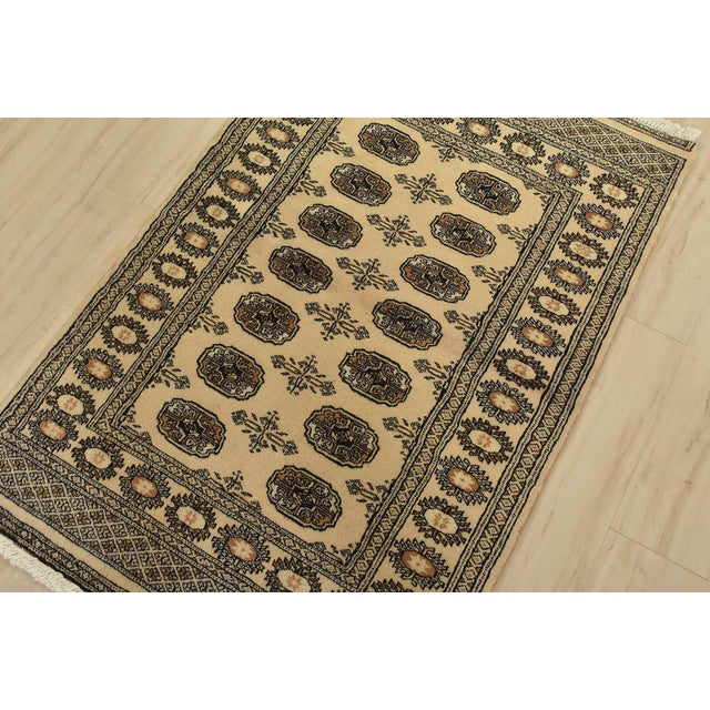 A tribal Bokhara rug hand-knotted with fine wool on a cotton foundation. This rug features rows of repeating medallions...