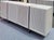 Cast aluminum legs/dividers and narrow slatted doors define this four-door white-washed solid acacia credenza from...