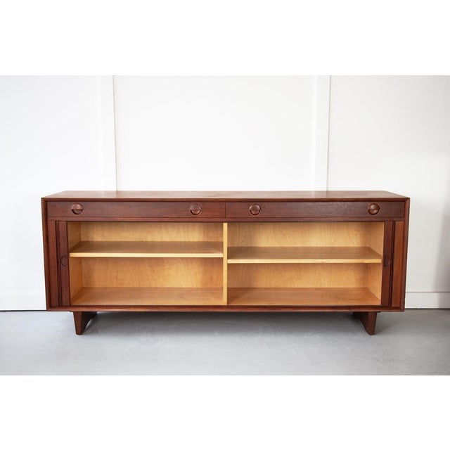 A beautiful Model 41 teak sideboard with tambour doors, designed by Grete Jalk for Sibast, Denmark. This sideboard...