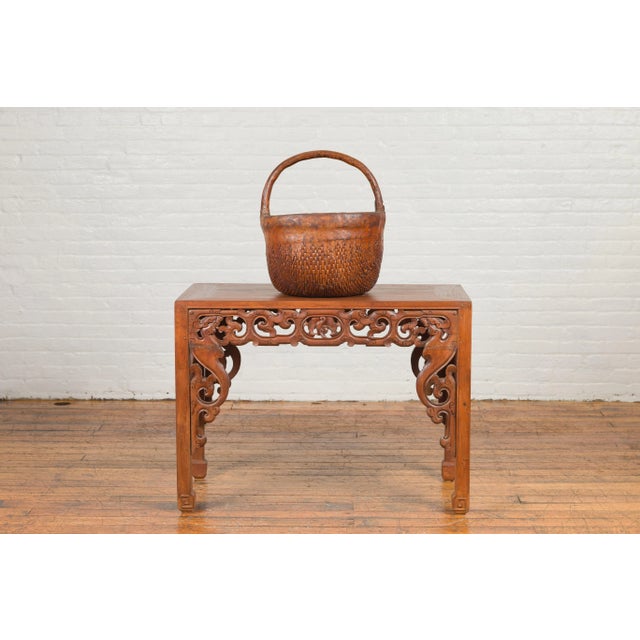 An antique Chinese carrying basket from the 19th century, with intricate woven rattan design. Created in China during the...
