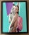 This artwork features a striking composition where a figure emerges from a torn, vibrant background, emphasizing the...