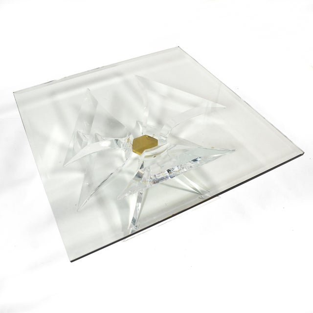 This dramatic coffee table by Lion in Frost is exquisitely crafted of three sculptural lucite legs joined by a central...
