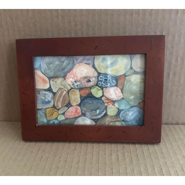 A vibrant study of rounded river rocks in various colors and textures. The artist’s close attention to light and natural...