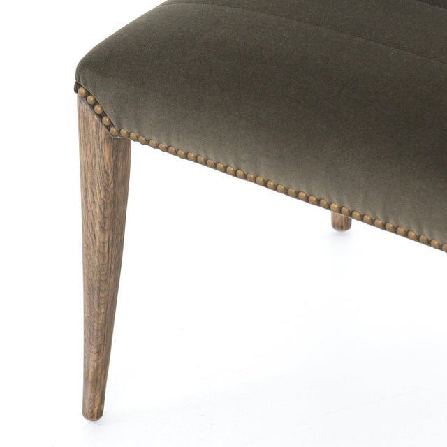 Clean mid-century shaping is updated via channeled, velvet-like seating in a greyish sage. Tapered oak legs and hand-...