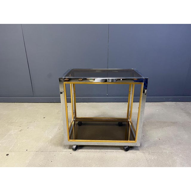Vintage brass and chrome bar cart with smoked glass tops. Cool contrasting chrome and brass frame. Good condition with...