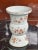 White Chinese porcelain vase in a unique form with brown, pink and yellow botanical details all around. Dimensions: 16"H x...