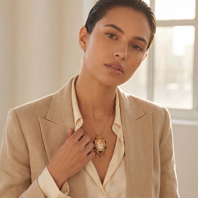 A vintage 12k gold cameo brooch and pendant. Features an intricate design with a central carved scene of a Goddess and a...