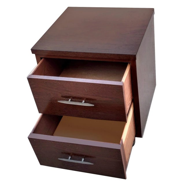 A petit Eames era style two pull drawer side cabinet / table with a dark walnut veneer finish. The small storage cabinet...