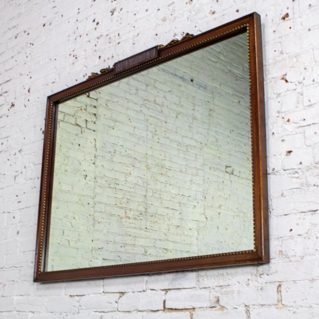Lovely vintage Traditional or Regency style rectangular wall mirror composed of a rectangular walnut toned hardwood frame...