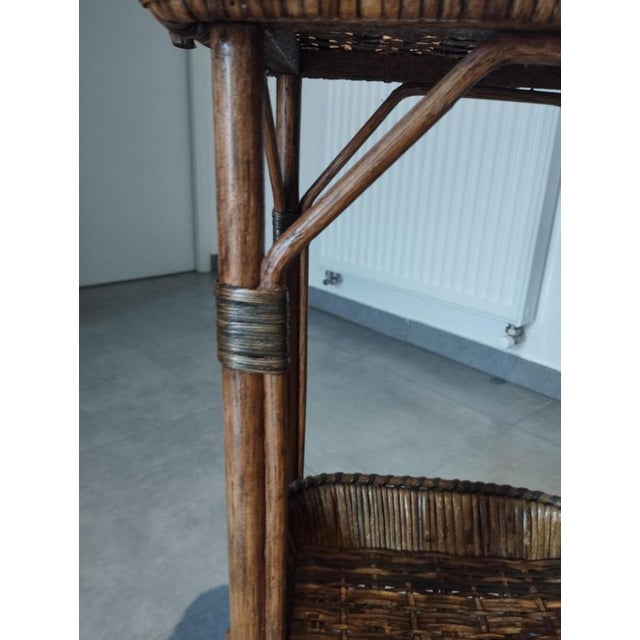 Antique side table: work table, side table, serving table. Made of honey-colored woven rattan and wicker, accented with...