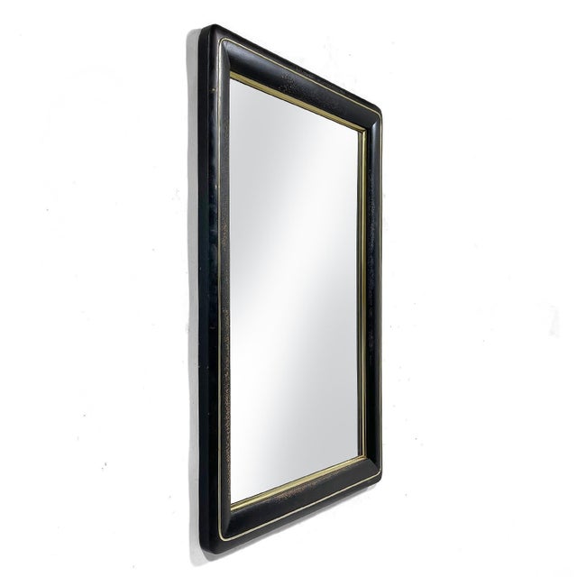 This handsome wall mirror has an elegant design with radiused corners and brass detail. The lacquer finish has distressed...