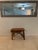 A rustic accent table featuring a thick, polished live-edge wood top with a warm natural finish. Supported by an organic...