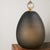 This sophisticated table lamp combines a minimalist, organically inspired silhouette with a bold interplay of contrasts...