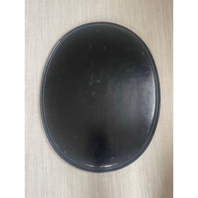 This huge paper Mache oval tray is sealed with a black lacquer and original had a gold gilded detail around the trim. The...