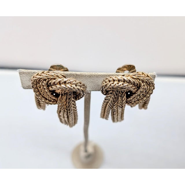 1950s goldtone two lines of chains in a knot shape with fringe dangles clip earrings. Marked "NAPIER PAT. PEND." Measure:...
