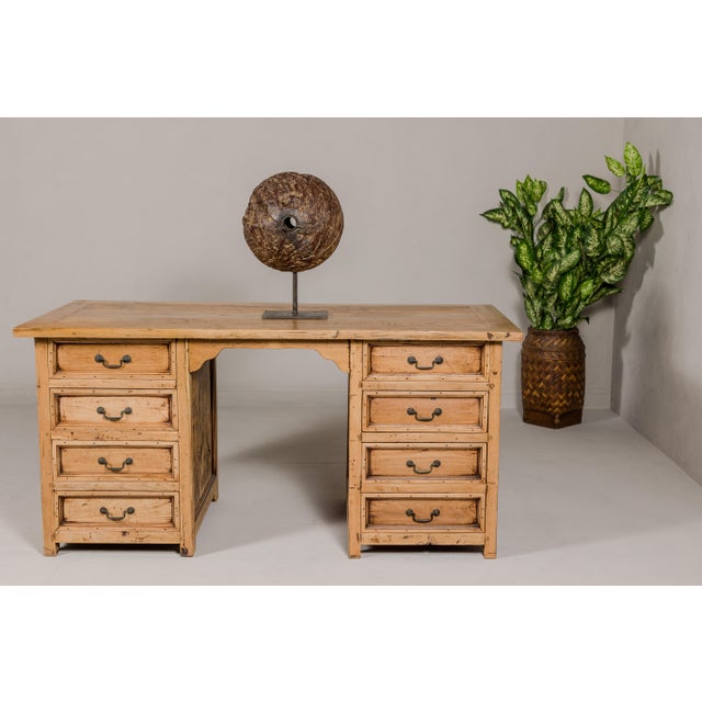 A vintage teak wood kneehole desk with custom bleached finish and eight drawers. Discover the understated elegance of this...