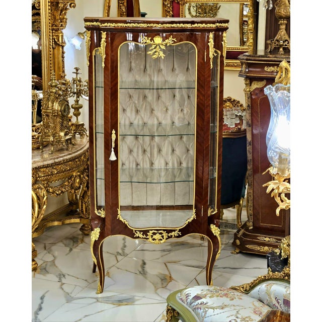 Showcase your most treasured collectibles in this magnificent French Louis XV Curio Display Cabinet, a luxurious statement...