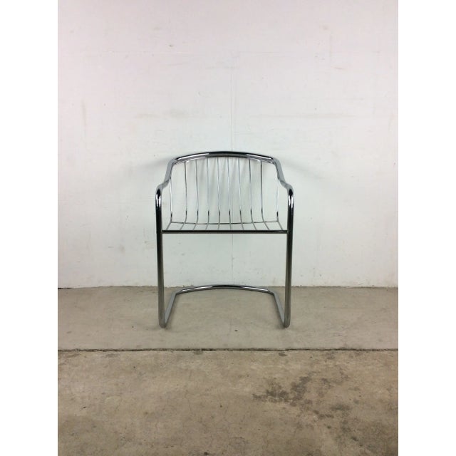 This mid century modern accent chair features original chrome finish, unique basket seat design, and cantilever base.