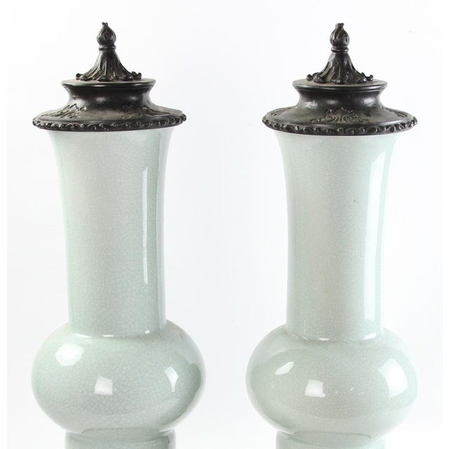 Pair of Chinese gu form celadon vases with metal covers and stands. Measuring 24" height x 8" diameter.