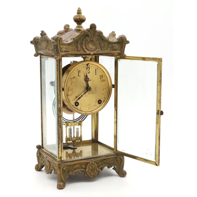 This French clock features beveled glass panels, a skeletal interior, and two opening doors. Made by New Haven Clock...