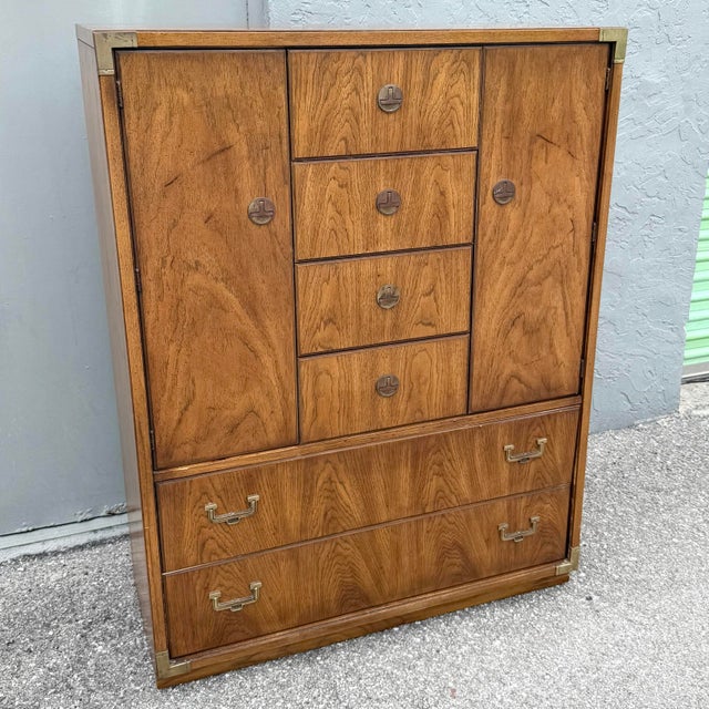 This vintage Huntley Campaign highboy dresser by Thomasville embodies the timeless appeal of campaign-style furniture with...
