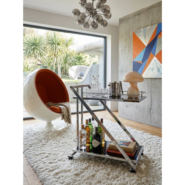 A rolling serving cart with an architectural "Z" design, typical of the 2000s and inspired by the Space Age aesthetic....