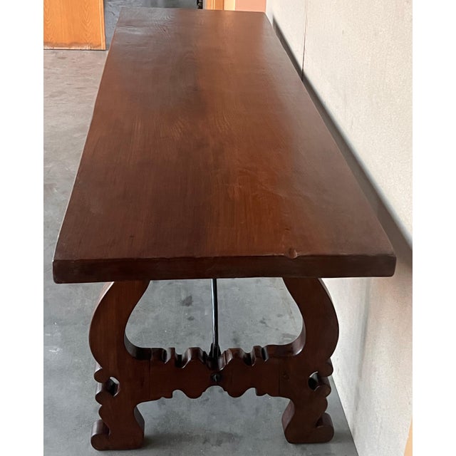 Dining table made of walnut with carved lyre legs and heavy top. The lyre legs are very thick. Beautiful iron stretcher,...