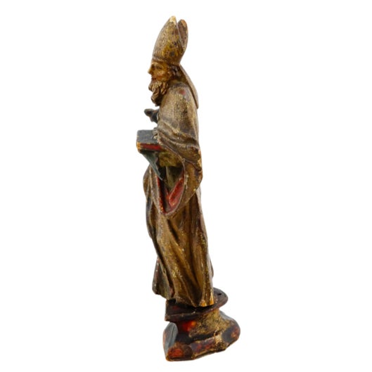 An evocative antique European religious sculpture depicting a Holy Bishop or saint, hand-carved in wood with beautifully...
