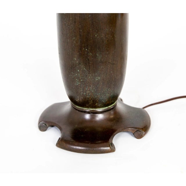 A heavy bronze table lamp in a beautiful shape, with a unique base and and original, rich patina with subtle green...