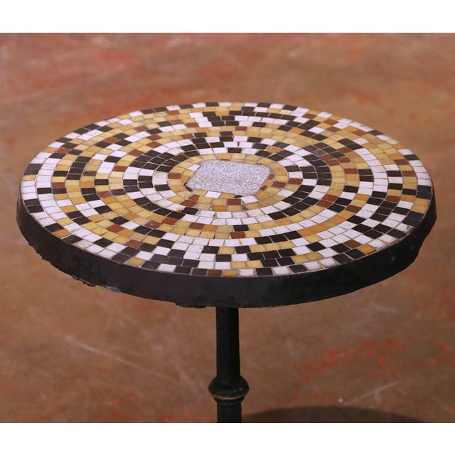Crafted in France circa 1840, this elegant antique guéridon features a circular marble and stone mosaic top set within a...