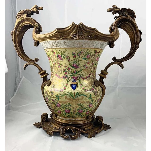 A fine pair of french porcelain and ormolu-mounted twin handled urns. Each heavy baluster body decorated with a coat of...