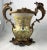 A fine pair of french porcelain and ormolu-mounted twin handled urns. Each heavy baluster body decorated with a coat of...