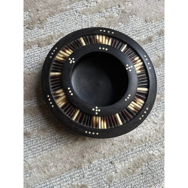 A unique porcupine quill and ebony trinket or change dish made of solid ebony with porcupine quills inserted around the...