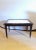 A small Ebonized Marble Top Coffee Table. Bronze mounted, in the Maison Jansen manner. This coffee Table is on wheels,...