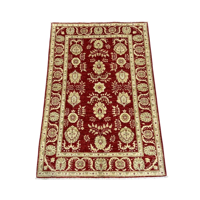 This Persian-style wool accent rug features an allover floral pattern in warm beige against a rich red field. A...
