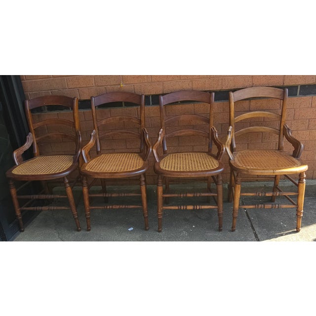A Set of Four Victorian Ladderback Walnut and Cane Seat Side Chairs with hip supports.