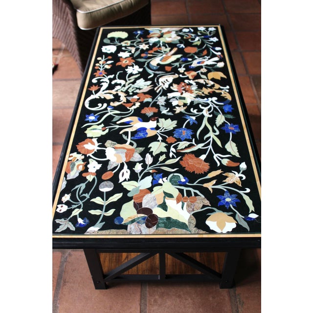A gorgeous black marble coffee/center table with hand-inlaid semi-precious stones in the Pietra Dura style. Beautiful...