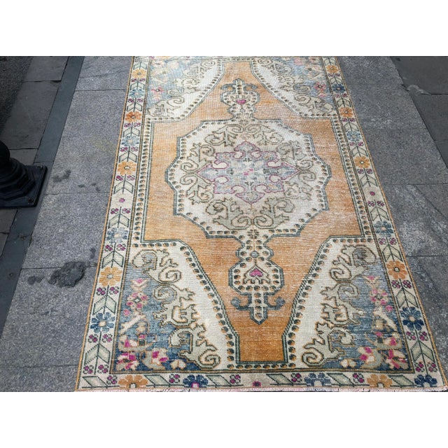 This is a vintage Turkish Oushak rug from the 1960s. The piece was hand-knotted.