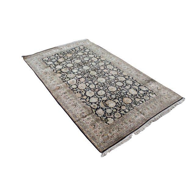 This hand-knotted rectangular area rug features an intricate, all-over botanical layout woven from a fine blend of wool...