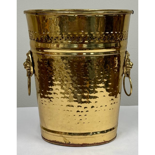 Vintage hammered brass umbrella stand or wastebasket with pierced detail and lion head handles to either side....