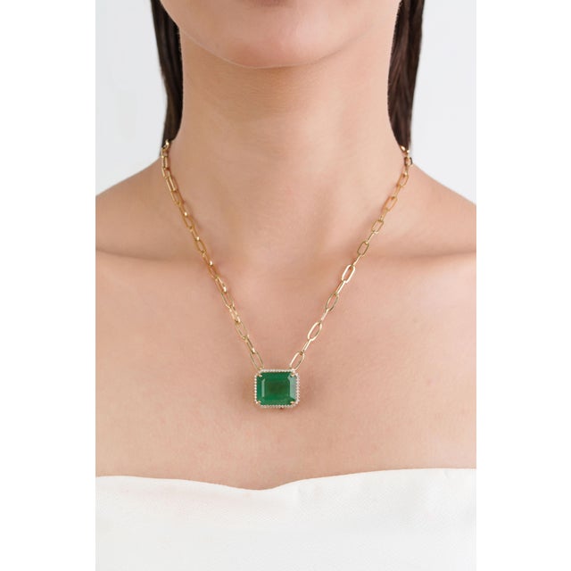 This statement pendant necklace features 18.82 carat emerald-cut emerald, set in 14k yellow gold. The center stone...