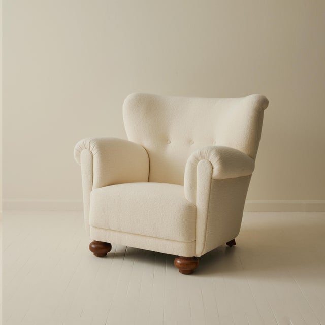 This mid‑century Danish lounge armchair, originally designed in the 1940s, features a generous wingback silhouette and...