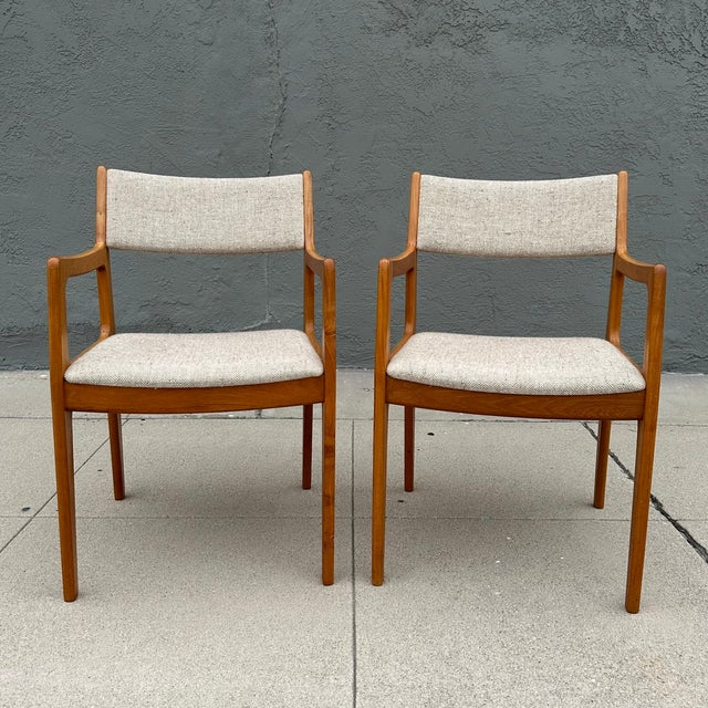 A pair of Scandinavian mid century modern solid teak captain’s chairs / armchairs with tweed upholstery, designed by...