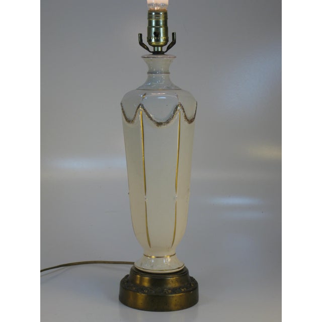 This French Empire Style Neoclassical table lamp is a vintage piece made of porcelain with a luxurious gold color and...