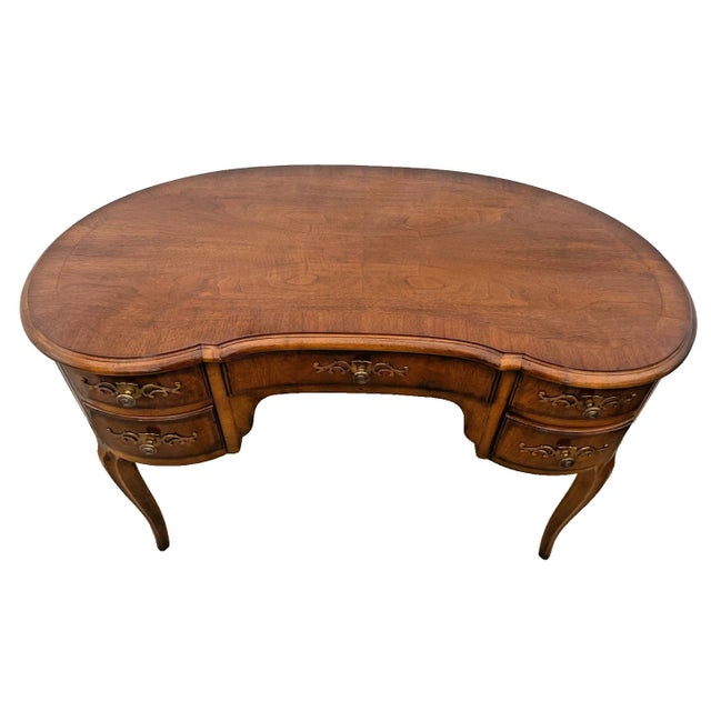 Elegant vintage Henredon kidney-shaped writing desk / vanity in a warm walnut finish. Crafted in the United States, this...