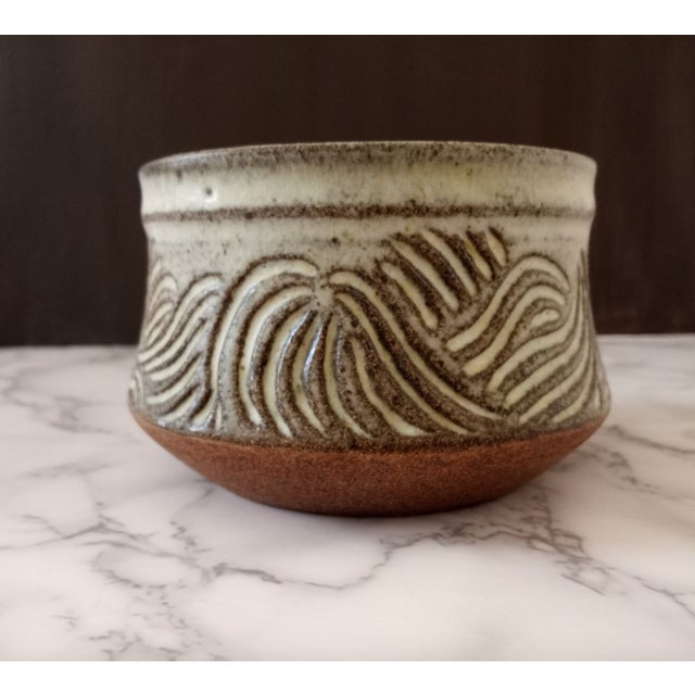 A striking hand-thrown studio stoneware bowl by artist Nora, dating to the 1970s American studio craft movement. The...