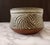 A striking hand-thrown studio stoneware bowl by artist Nora, dating to the 1970s American studio craft movement. The...