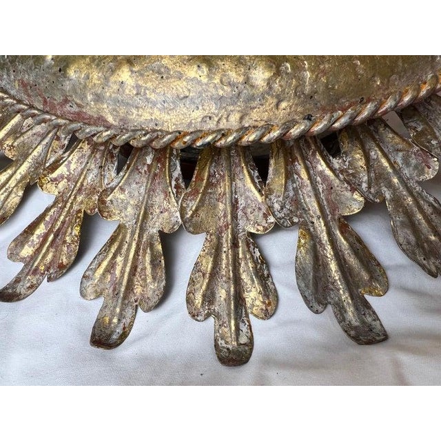 Striking gilt iron ceiling mount light fixture in the form of a radiant sunburst, designed by Miamar Home. This sculptural...